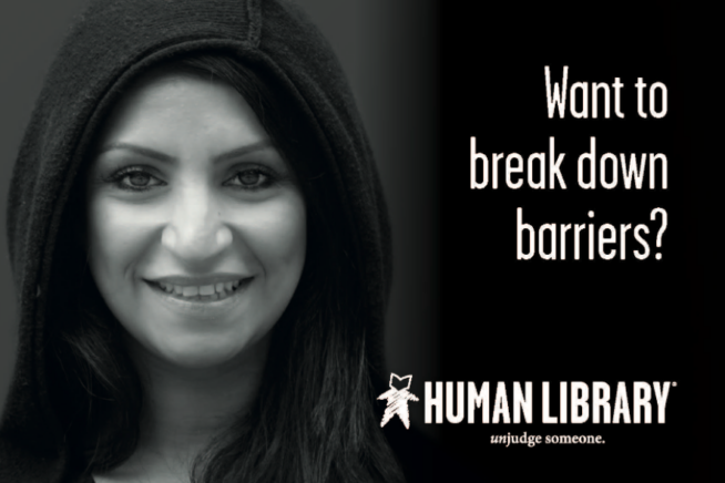 Black and white image of a person smiling in a hooded top. Text: Want to break down barriers? Human Library logo bottom right corner